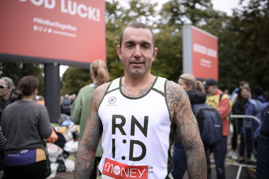A runner pictured at a race in an RNID vest