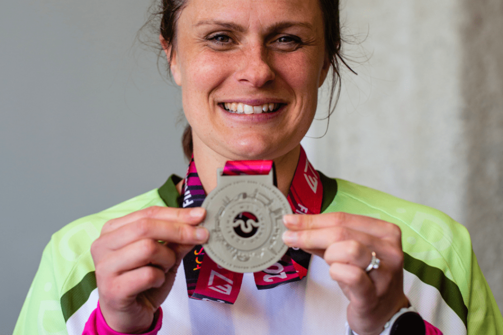 Woman smiling with London Marathon medal in a RNID vest