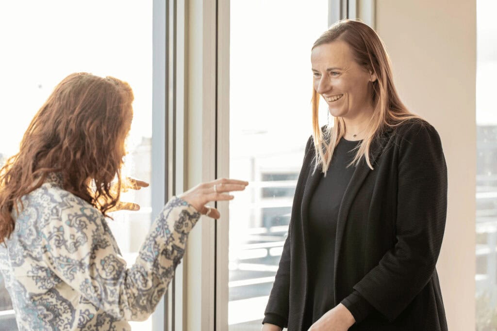 Two people speaking and smiling.