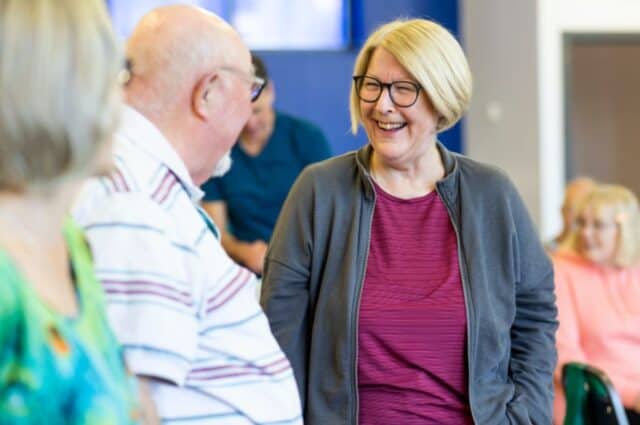 Two people smiling and talking at an event