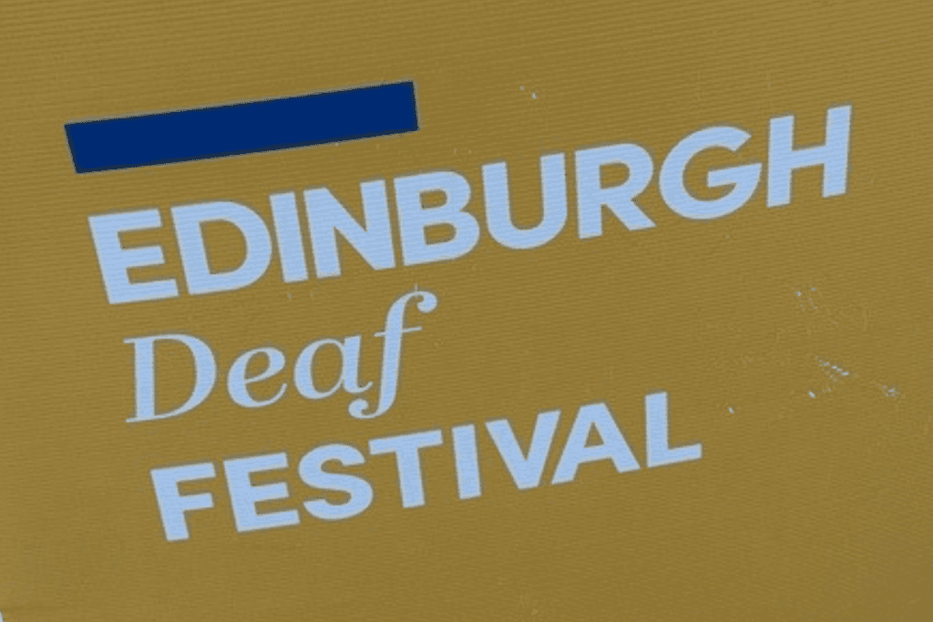 An outdoors poster saying "Edinburgh Deaf Festival"