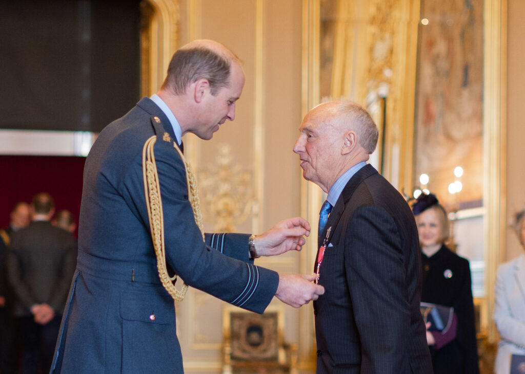 Photograph of Brian receiving his MBE from Prince William