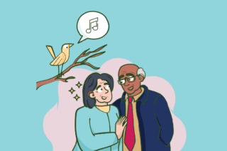 An illustration of a couple who are both wearing hearing aids. They stand beside a tree which has a bird on a branch singing.
